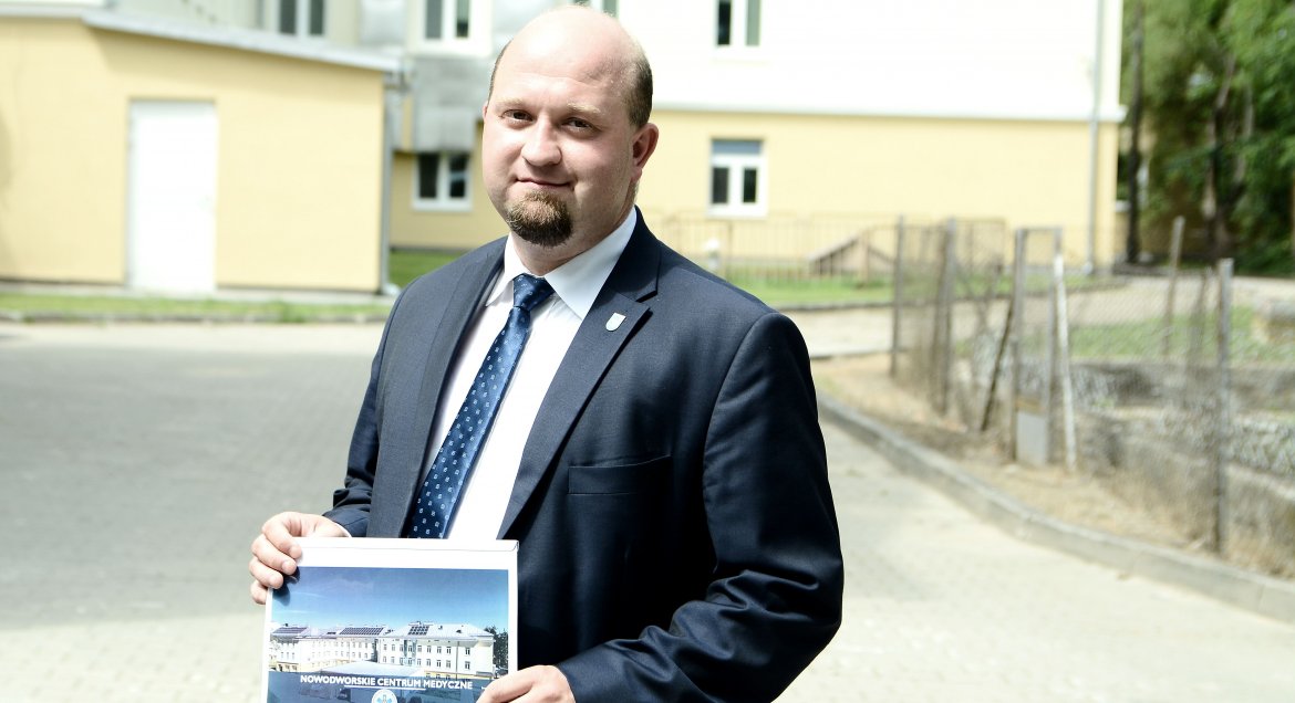 Na zdjęciu ubrany w garnitur wicestarosta legionowski Konrad Michalski na tle  Nowodworskiego Centrum Medycznego.