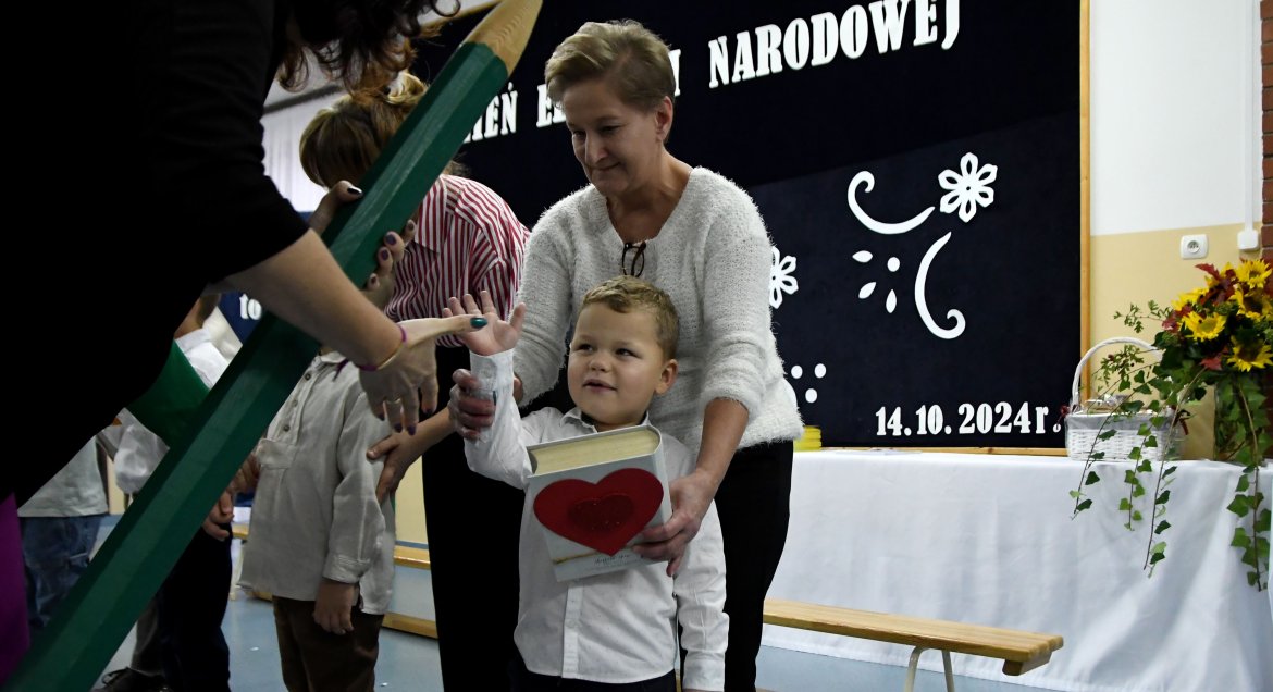 Na zdjęciu widać uczniów odbierających pasowanie na ucznia.