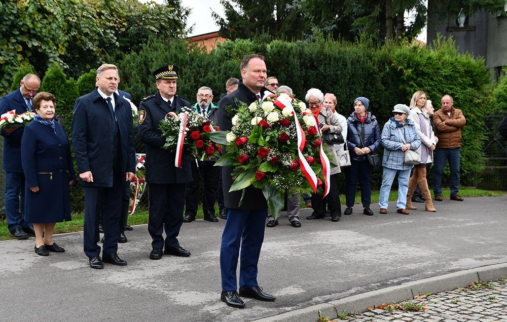 Zdjęcie z obchodów, grupka ludzi, reprezentacja z wieńcem