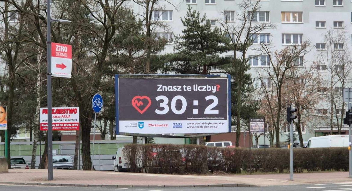Billboard przy ulicy z napisem Znasz te liczby? 30:2 i logotypy