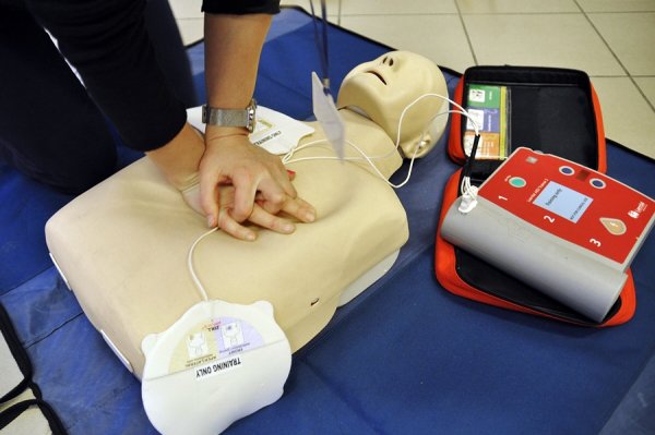 Manekin ratowniczy o AED oraz ręce uciskające manekina