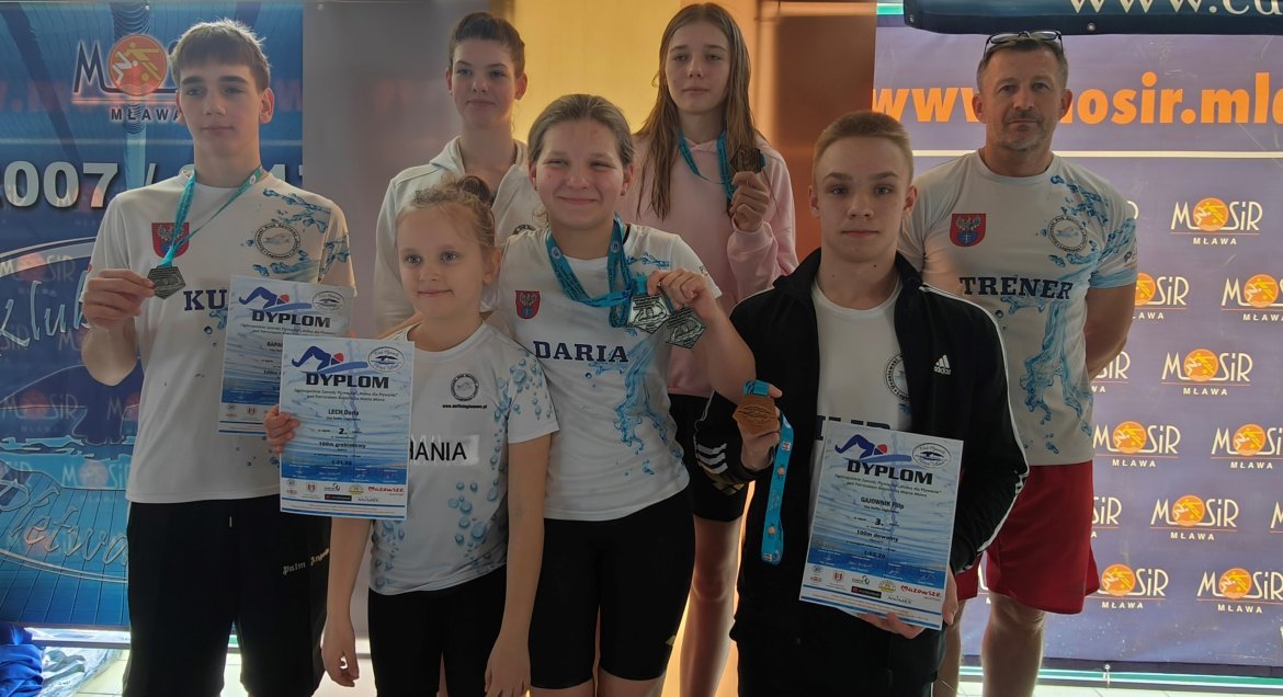 Na zdjęciu zawodnicy UKS Delfin z medalami i dyplomami oraz trener