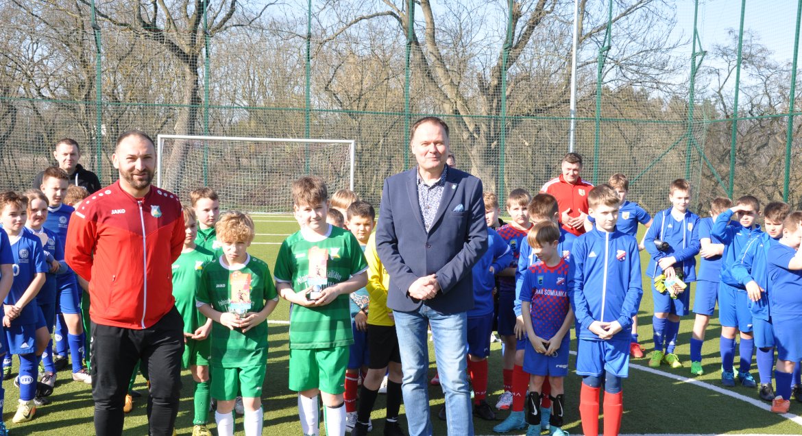 Grupa zawodników z medalami na boisku