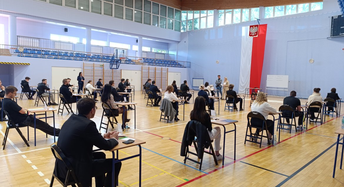Uczniowie Powiatowego Zespołu Szkół w Serocku w trakcie egzaminu maturalnego z matematyki, na sali gimnastycznej.