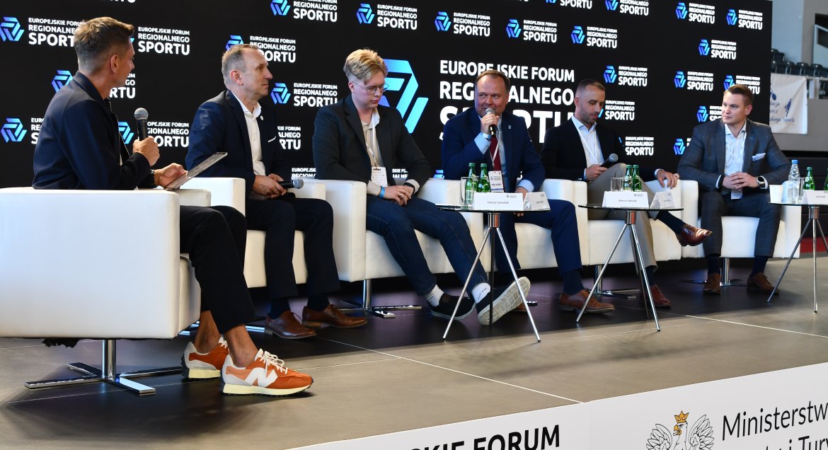 Prelegenci na Forum, siedzą w fotelach, na tle ścianka