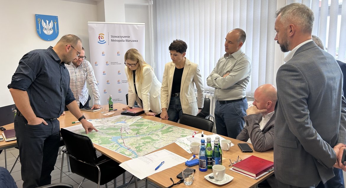 Grupa ludzi pchylona nad mapą