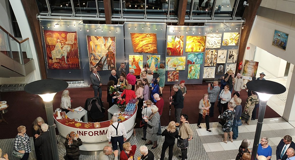 Zdjęcie, widok z góry na prace w Galerii Ratusz w Legionowie i gości zabranych na wernisażu.