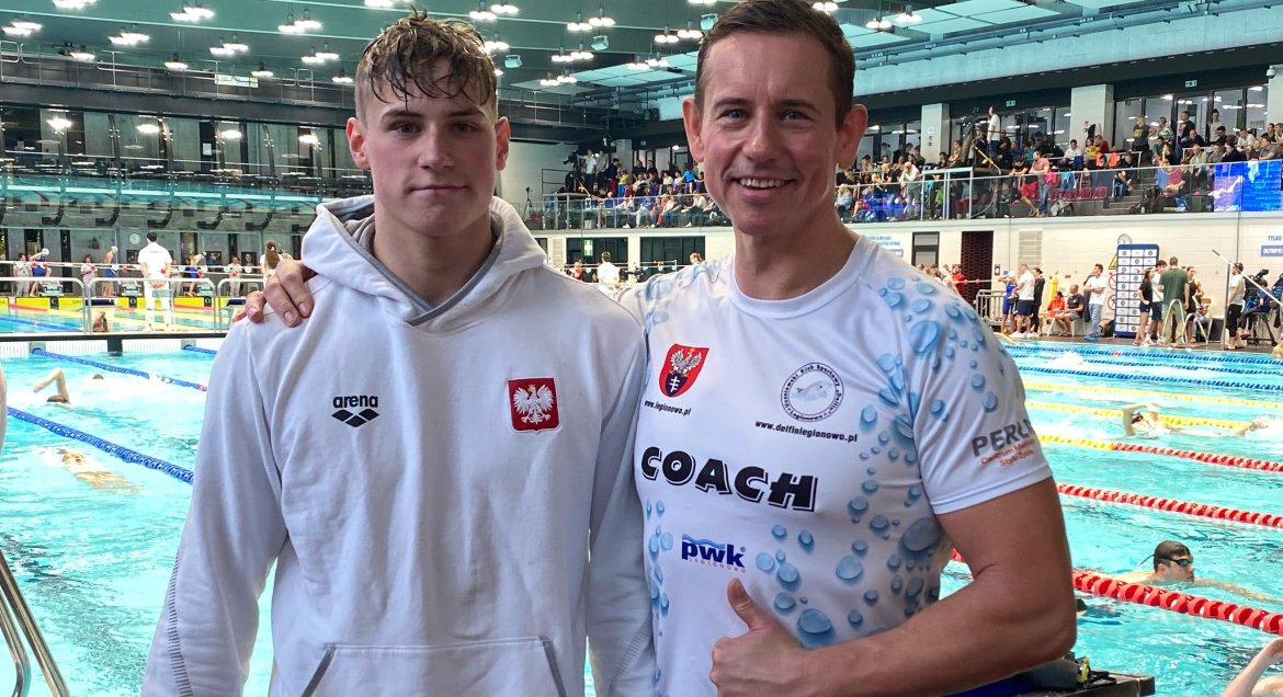 na zdjęciu Maciej Perl z trenerem na tle pływalni