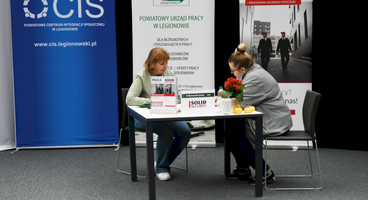 Zdjęcie: dwie osoby przy stoliku podczas rozmowy rekrutacyjnej.