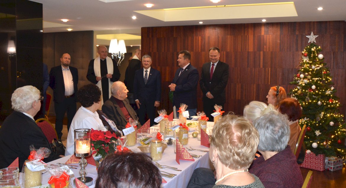 Zdjęcie z Wigilii, przedstawiciele Powiatu stoją przed zebranymi