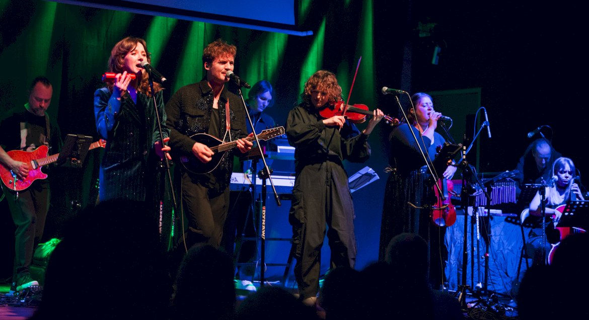 Grupa muzyków - wokalisci i instrumentaliści - na scenie w legionowskim ratuszu.