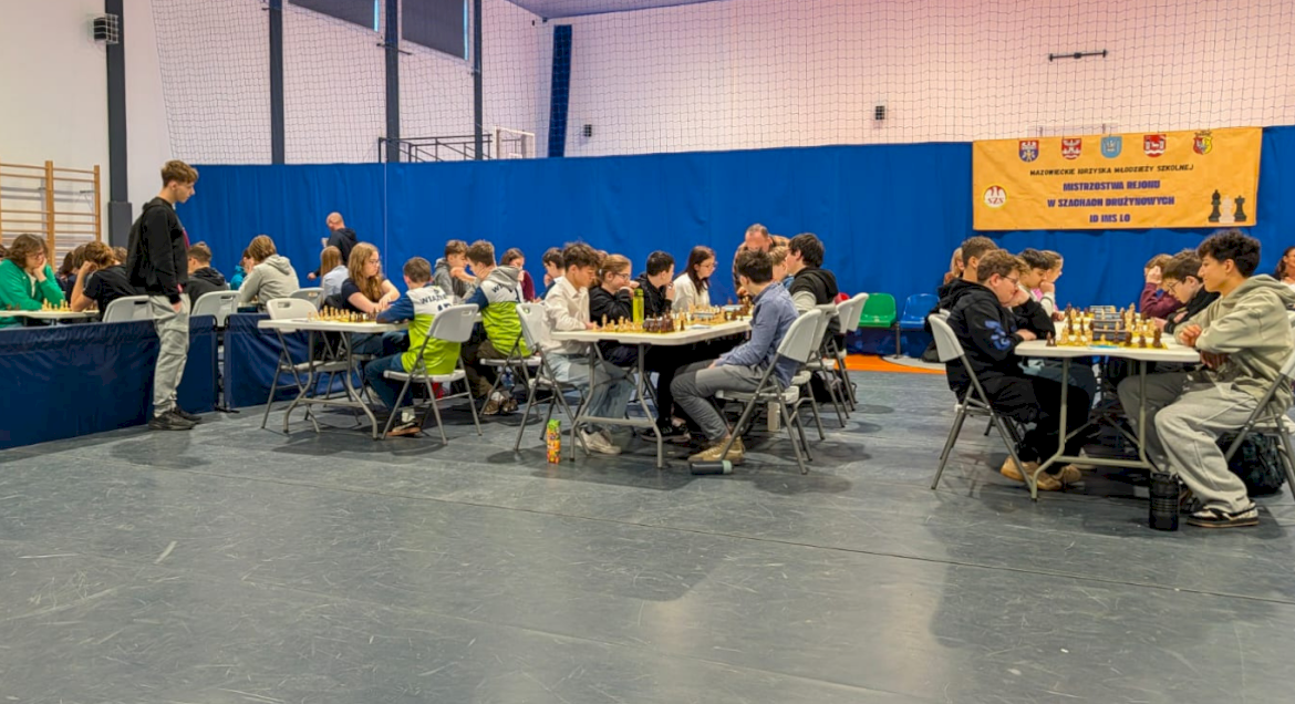 Na zdjęciu siedzący przy stołach szachiści w trakcie zawodów