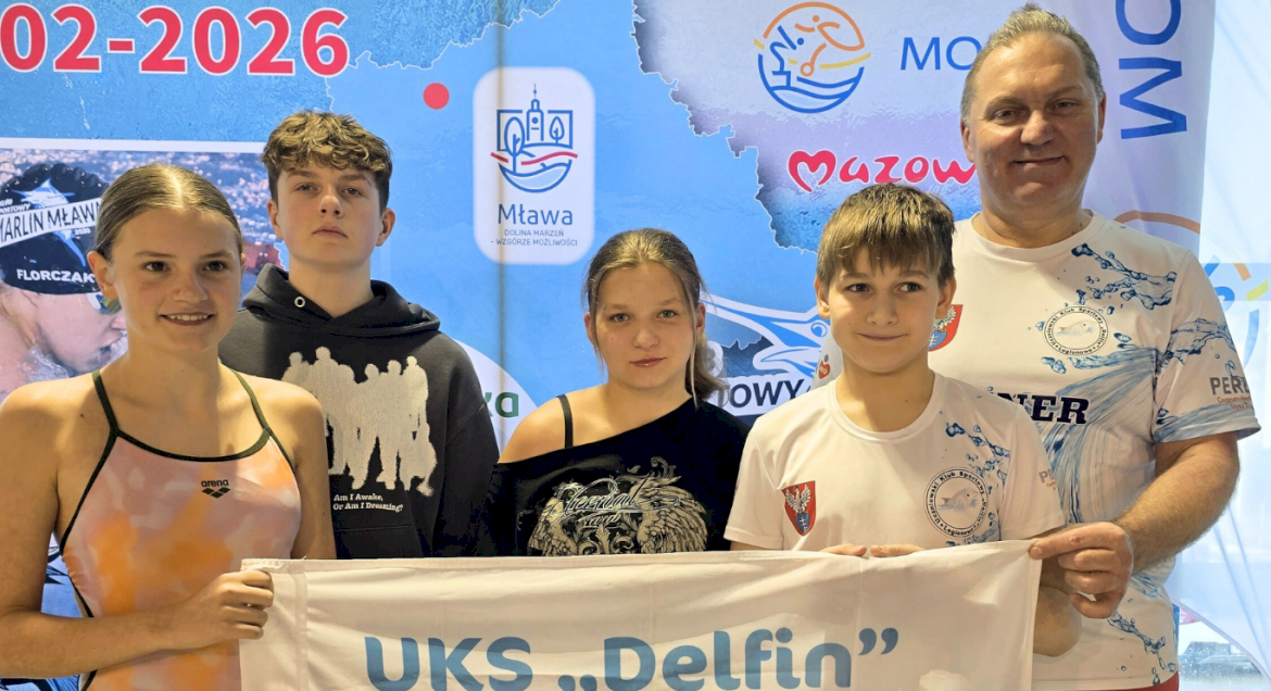 Na zdjęciu widać czterech uczestników zawodów pływackich i ich trenera