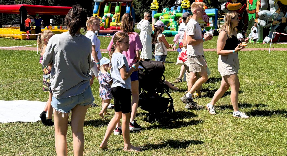 Grupa osób w róznym wieku na plenerowym pikniku na terenie Kompleksu Rekreacyjno-Wypoczynkowego Nieporęt-Pilawa.