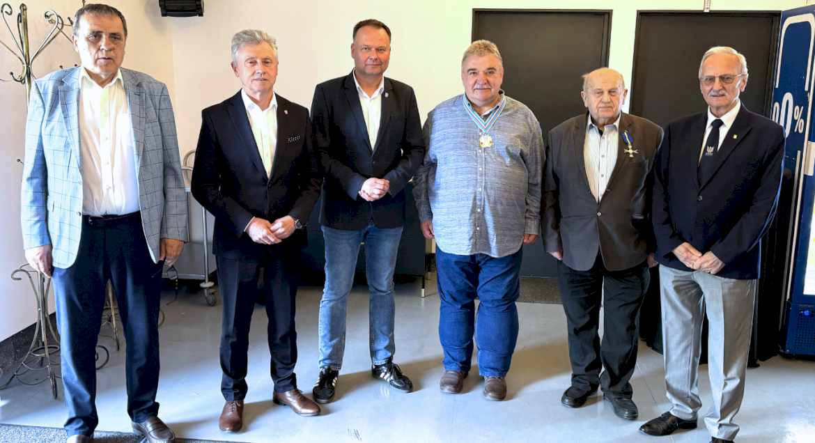 Na zdjęciu widać sześciu mężczyzn, którzy ubrani są w eleganckie stroje, a na klapach i marynarek widnieją odznaczenia