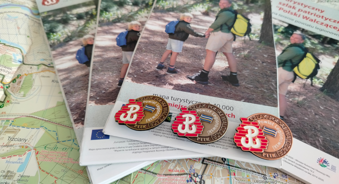 Na zdjęciu widać mapę z powiatem legionowskim i trzy odznaki szlaku Polski Walczącej