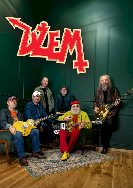 Na zielonym tle widać stojących sześciu muzyków z brodami i gitarami w tle a nad nimi duży czerwony napis dżem