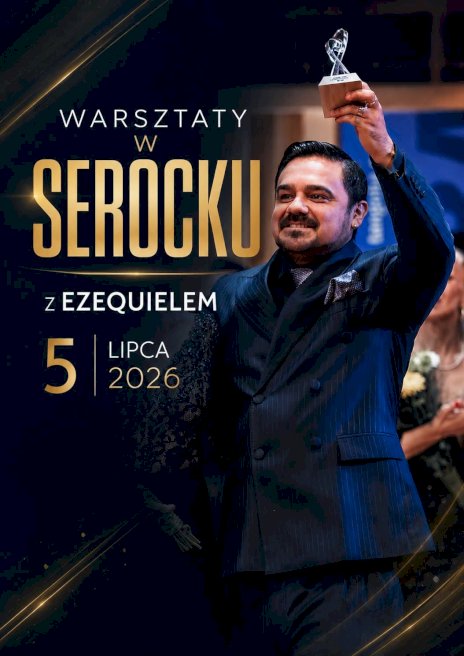 Na zdjęciu na czarnym tle widać tancerza mężczyznę ubranego w granatowy garnitur z uniesioną do góry lewą ręką w której trzyma statuetkę