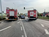 Zdjęcie z wypadku, trzy wozy strażackie, radiowóz, w tle wrak auta oraz ambulans. fot. Komenda Powiatowa Państwowej Straży Pożarnej w Legionowie