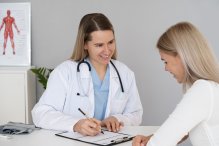 na zdjęciu pani doktor, na przeciwko pacjentka tyłem, siedzą w gabinecie
