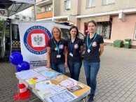 Zdjęcie stoiska Sanepidu, 3 osoby stoją przy stoliku, na nim materiały edukacyjne