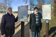 2 osoby stoją przy tablicach szlaku Polski Wajczącej