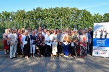 Zdjęcie grupowe seniorów na dworze, z boku rollup