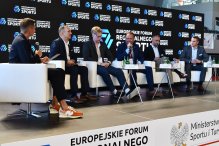 Prelegenci na Forum, siedzą w fotelach, na tle ścianka