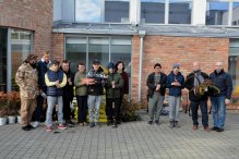 Na zdjęciu uczniowie i przedstawiciele Powiatu z roślinami i akcesoriami na tle szkoły