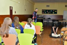 Na zdjęciu osoba ucząca się RKO na fantomie, z boku siedzą inni uczestnicy szkolenia