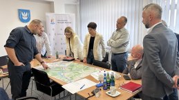 Grupa ludzi pchylona nad mapą