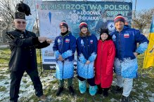 pływacy na tle ścianki z zawodów, obok górnik