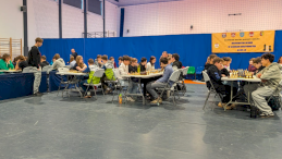 Na zdjęciu siedzący przy stołach szachiści w trakcie zawodów