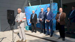 Na zdjęciu widać grupę mężczyzn przedstawicieli różnych środowisk, w tym jeden z nich przemawia przez mikrofon