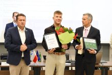 Stanisław Telejko z kwiatami i dyplomem oraz starosta i przewodniczący Rady