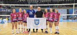 Zawodniczki z trenerem i flagą Powiatu