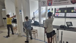 Powiększ obraz: fot. Legionowskie Towarzystwo Sportowe. Na zdjęciu osoby strzelają do tarcz z broni pneumatycznej