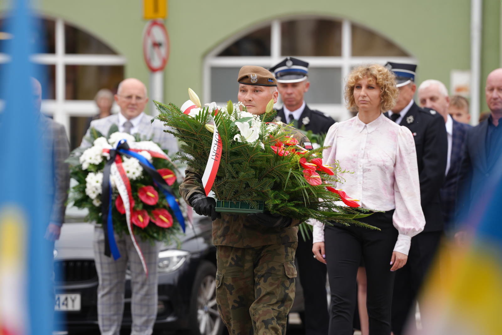 Radna Olga Wierzbicka składa kwiaty pod tablicą pamiątkową w Serocku