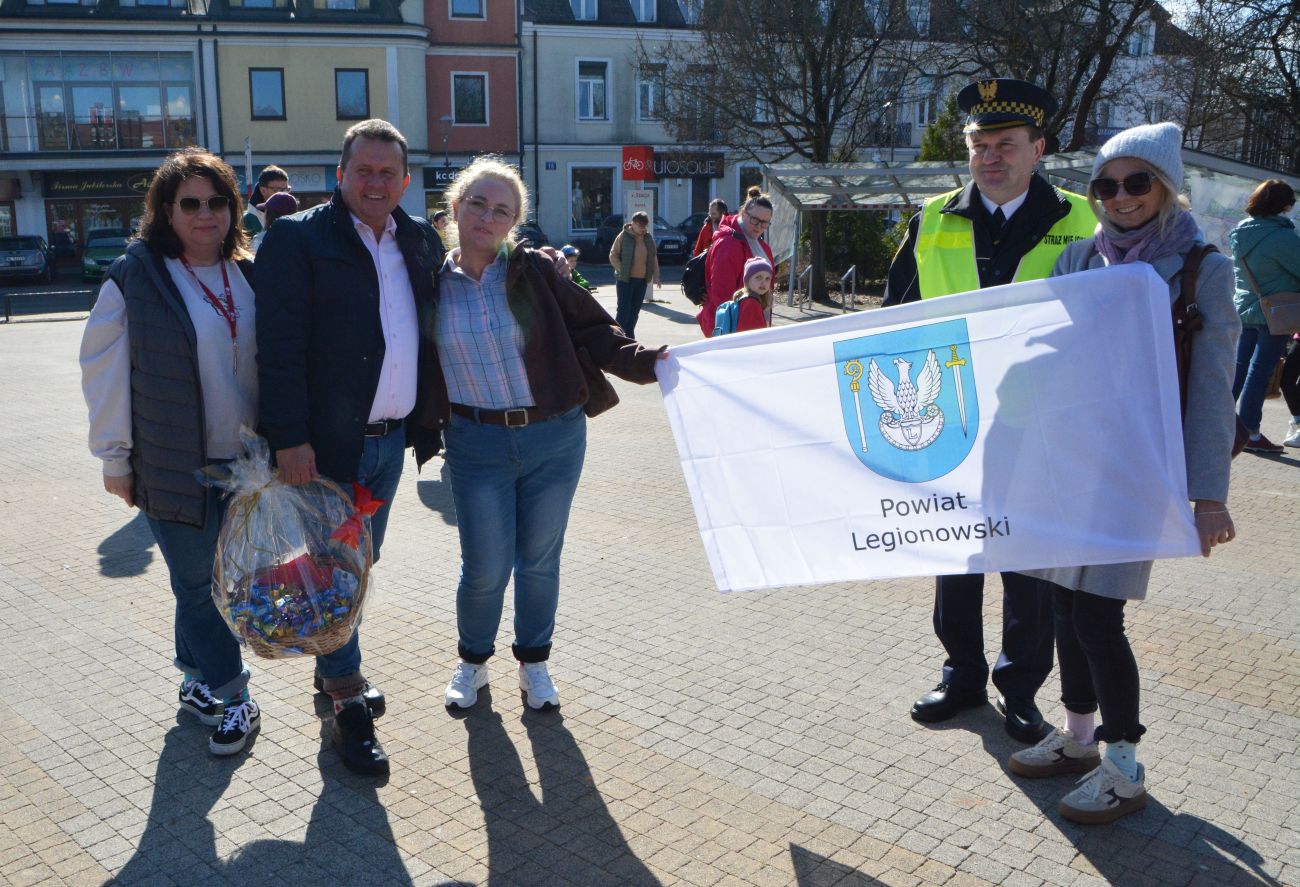 Na zdjęciu starosta Roman Smogorzewski i pracownice starostwa z flagą Powiatu Legionowskiego