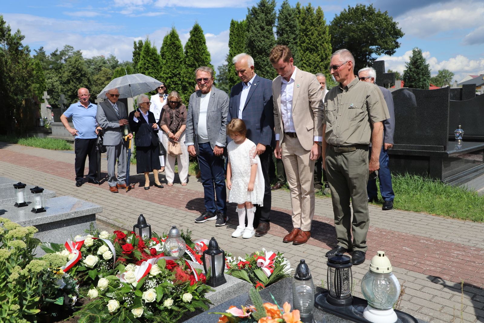 Członkowie delegacji pochylający głowy przy grobie poległych w walkach